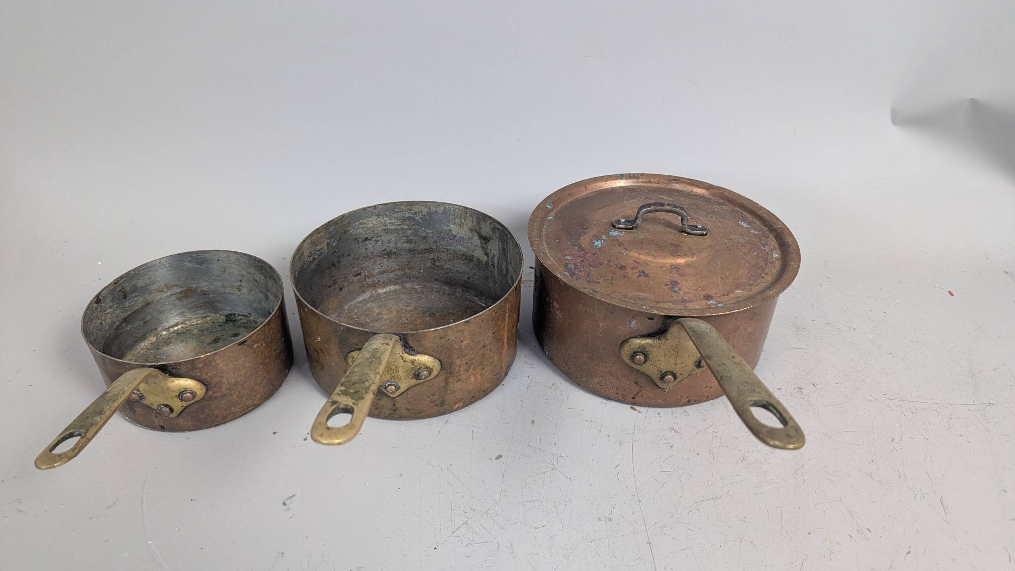 Three Matching Antique Copper Pots with Brass Handles and One Lid